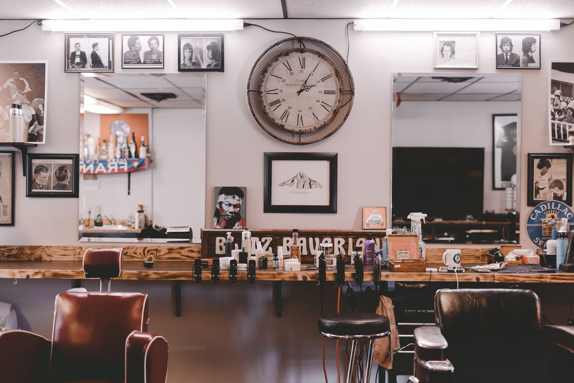 Barbershop interior with leather chairs, mirrors and framed photos on the wall